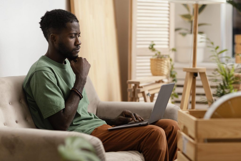 A Kenyan Man looking at his laptop. List your property online in Kenya.
